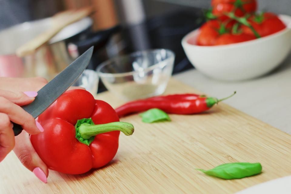 Woman slicing a red bell pepper