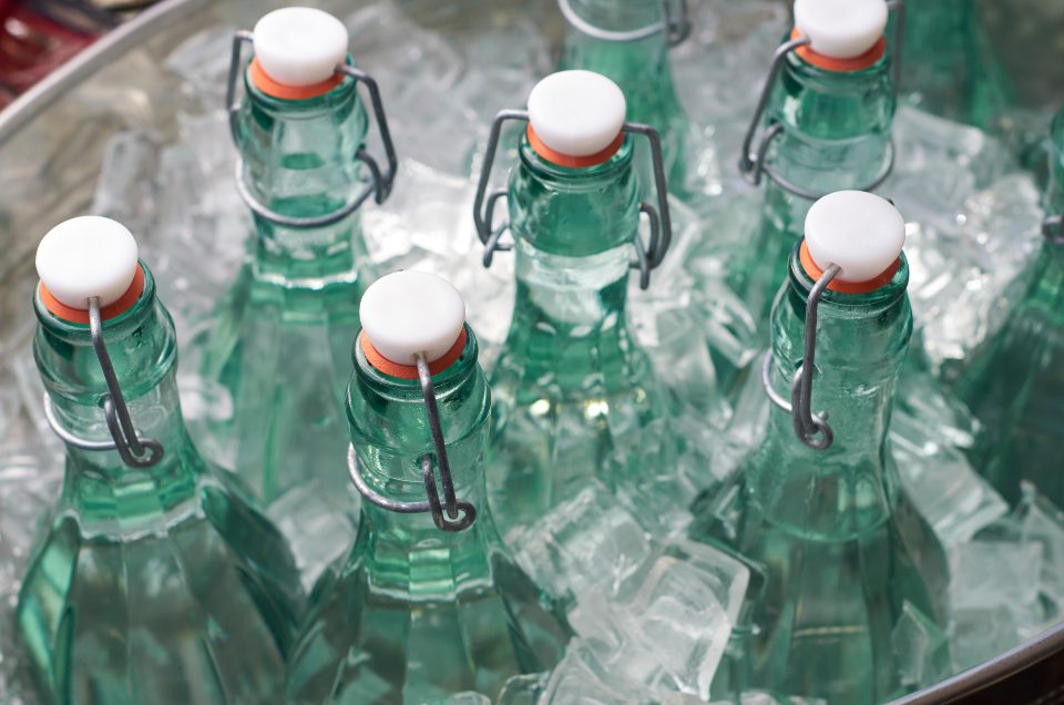 Glass bottles of water on ice