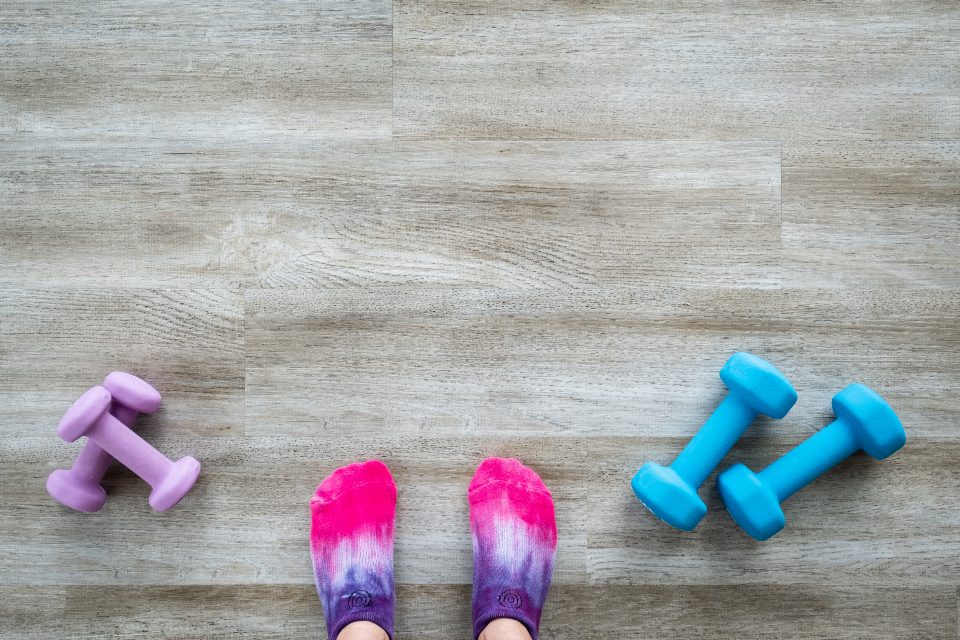 Small colored dumbbells and socks on a wooden floor