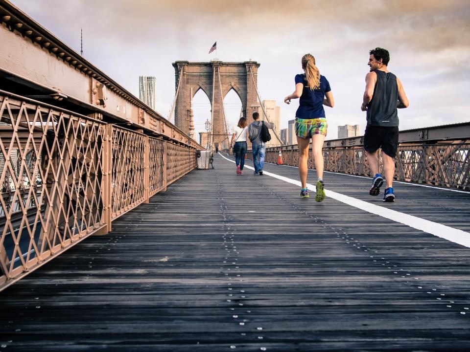 Two runners crossing a bridge
