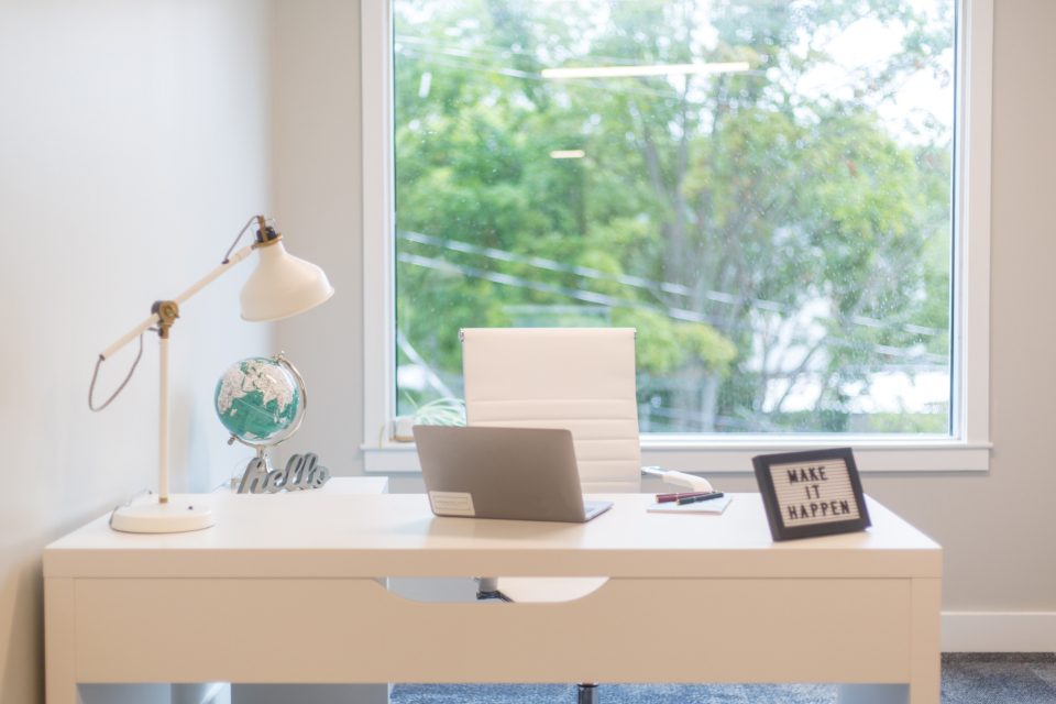 Bright home office desk with a laptop and lamp