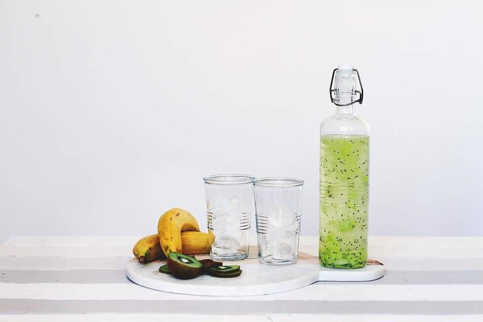 Bottle of lime and kiwi infused water with glasses